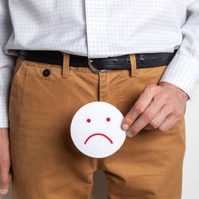 a person holding a paper with a sad face on their pants