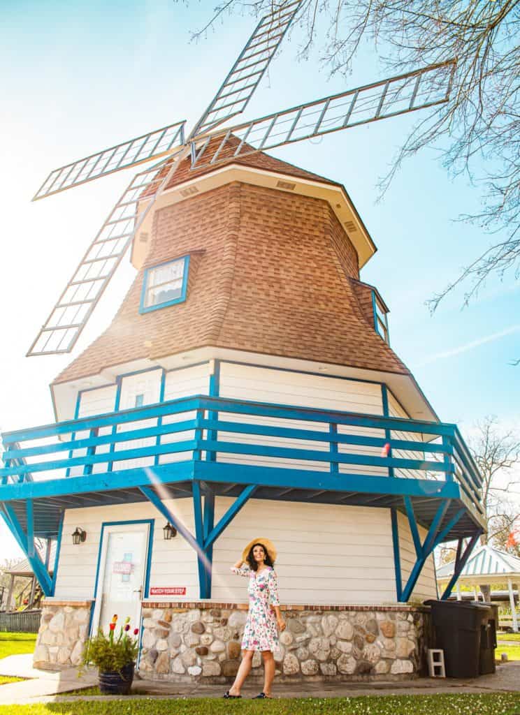 a woman standing in front of a windmill