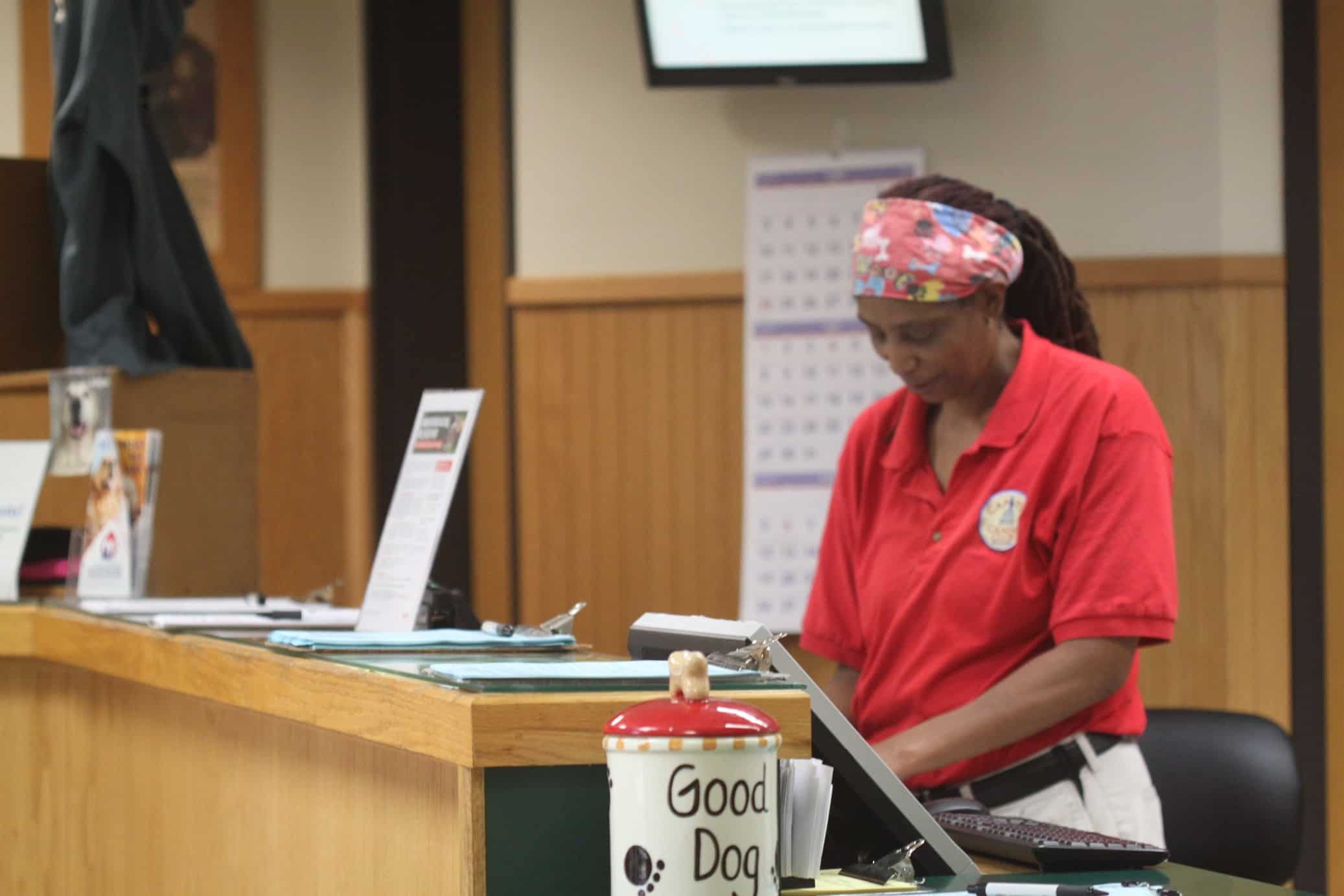 a woman in a red shirt at a desk