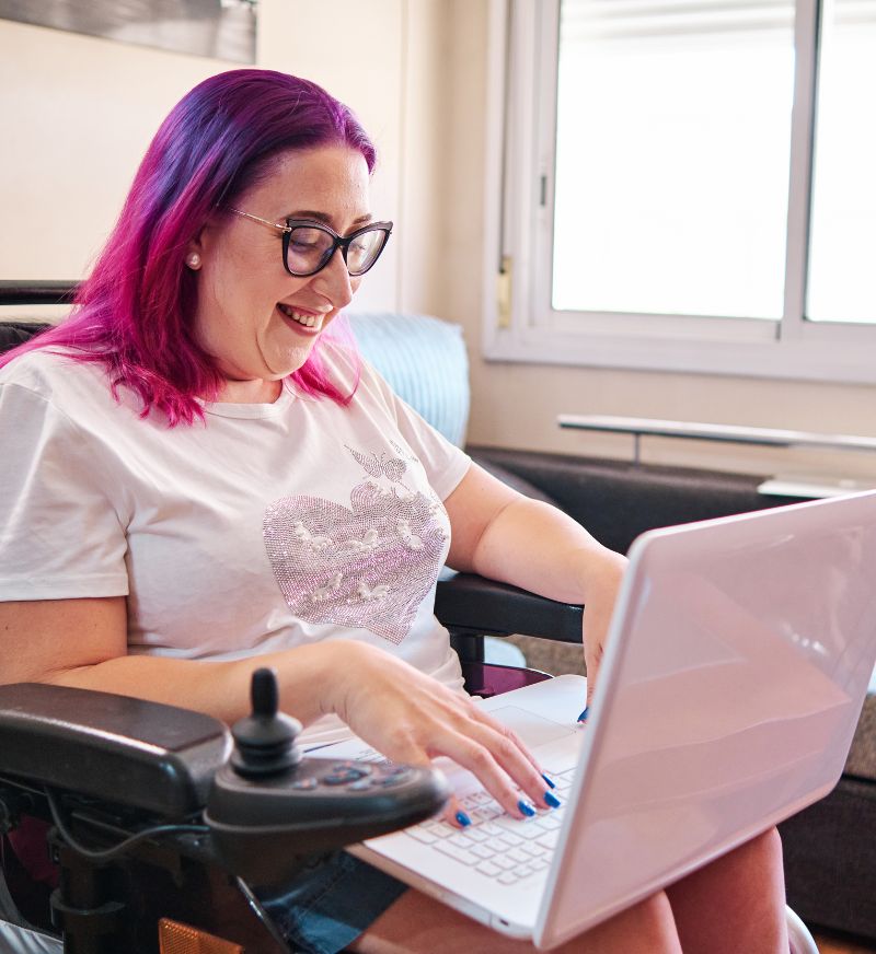 a woman in a wheelchair using a laptop