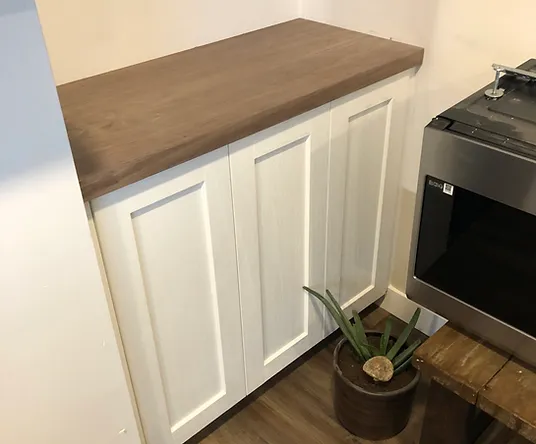 a white cabinets next to a microwave