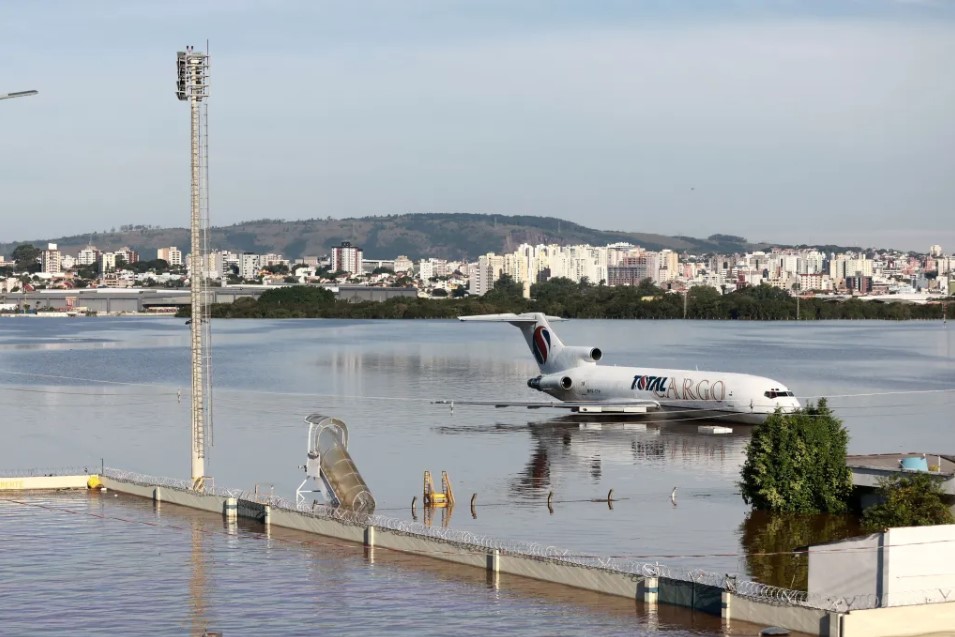 a plane in water with a body of water and a city in the background
