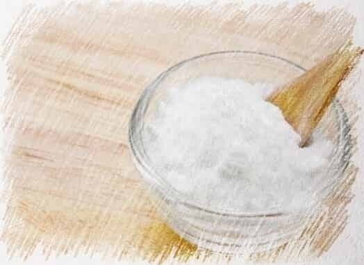 a bowl of salt with a wooden spoon