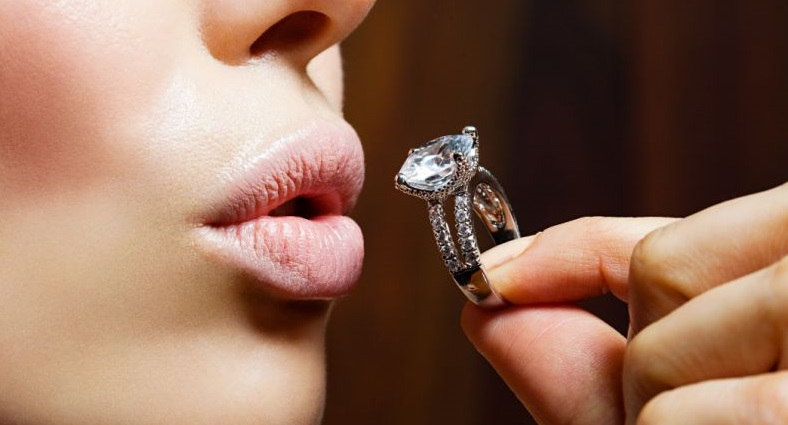 a close-up of a woman kissing a ring