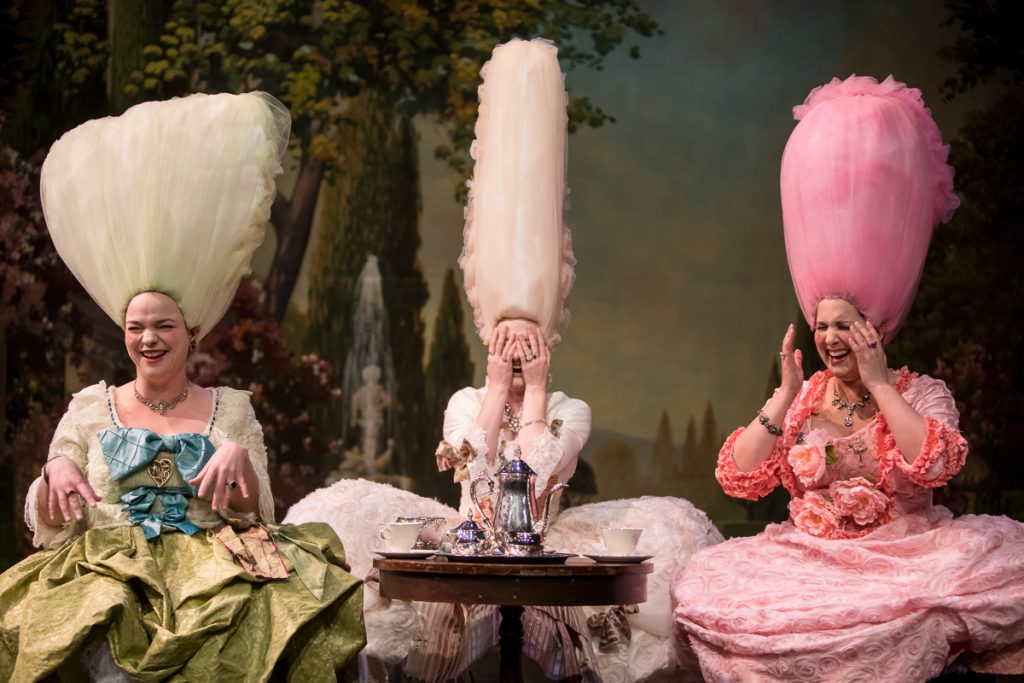 a group of women in dresses with large tulle hats on their heads