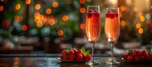 two glasses of pink liquid with berries on a plate