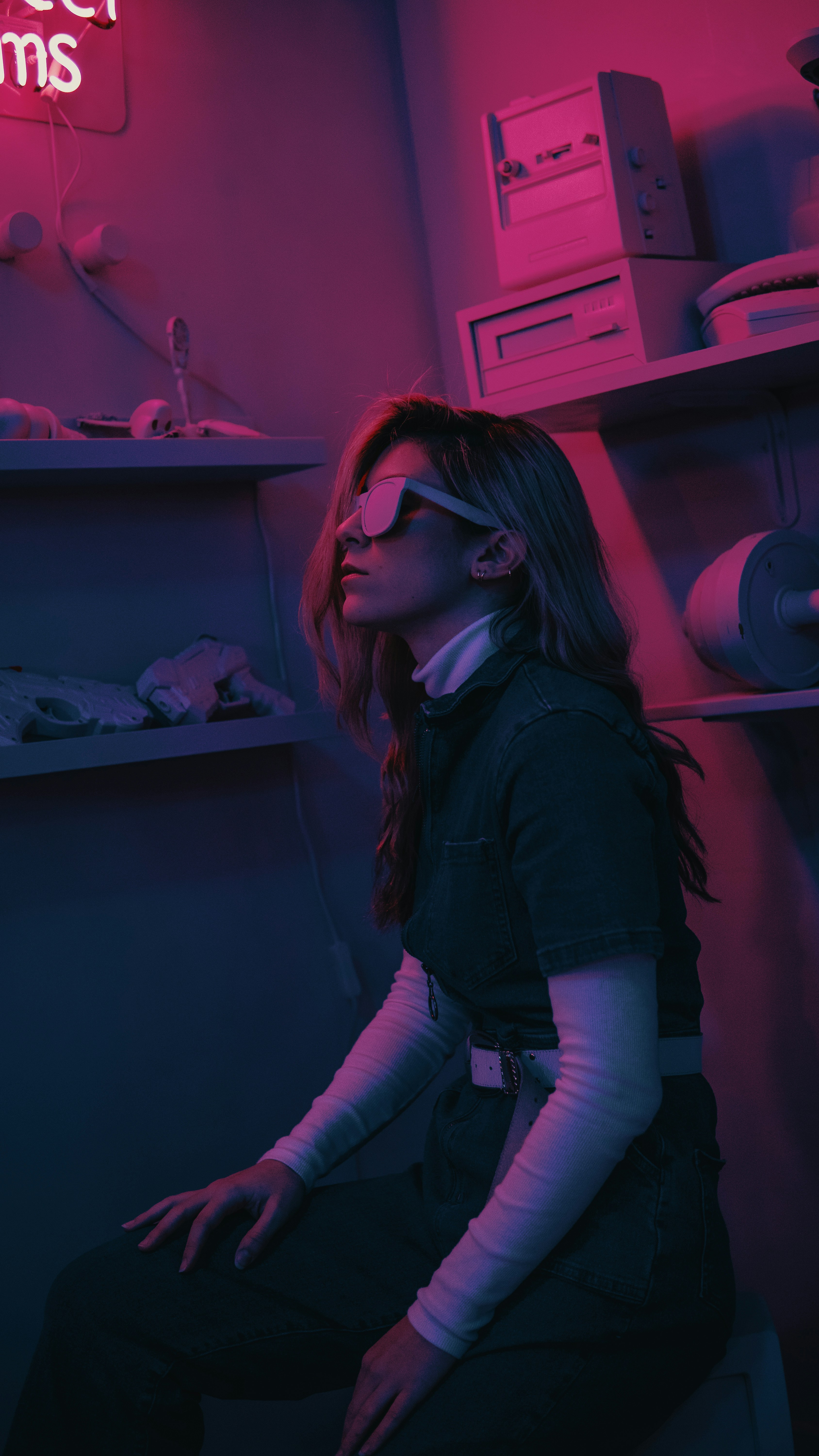 a woman wearing sunglasses and sitting in a room