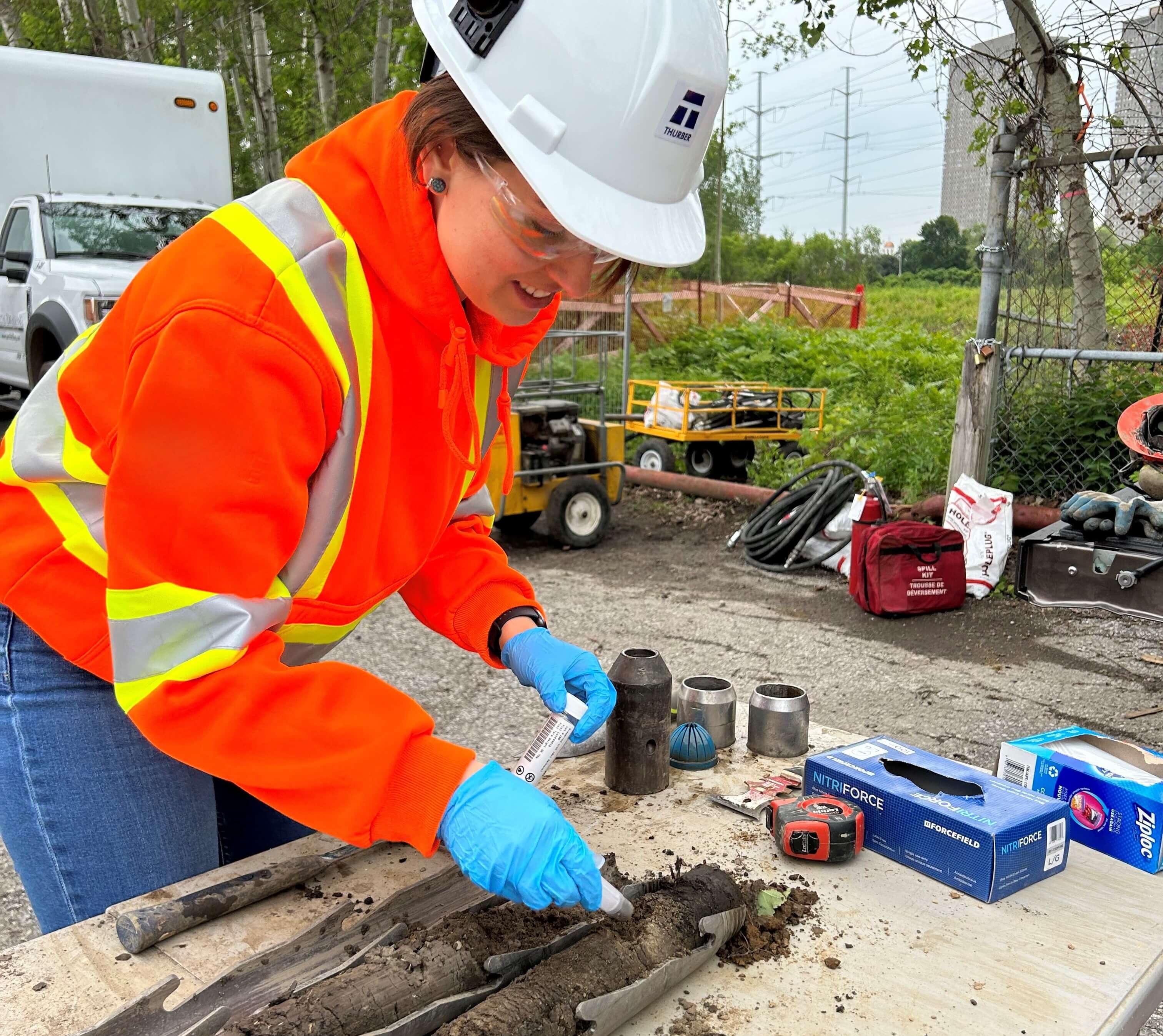a woman in a hard hat and safety vest working on a construction site