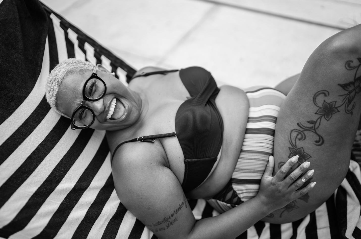 a woman in a swimsuit lying on a beach chair