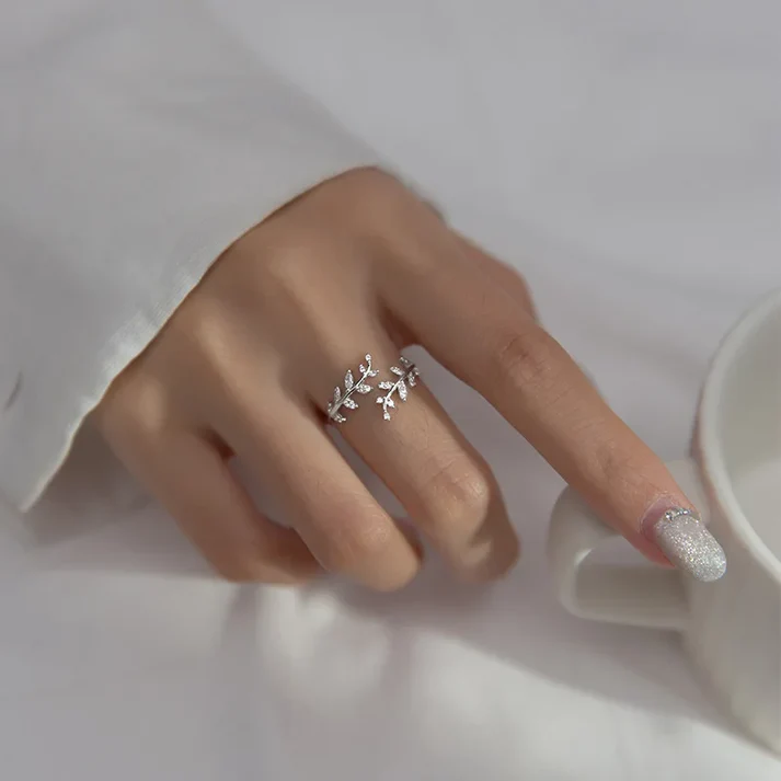 a hand with a silver ring and a cup of coffee