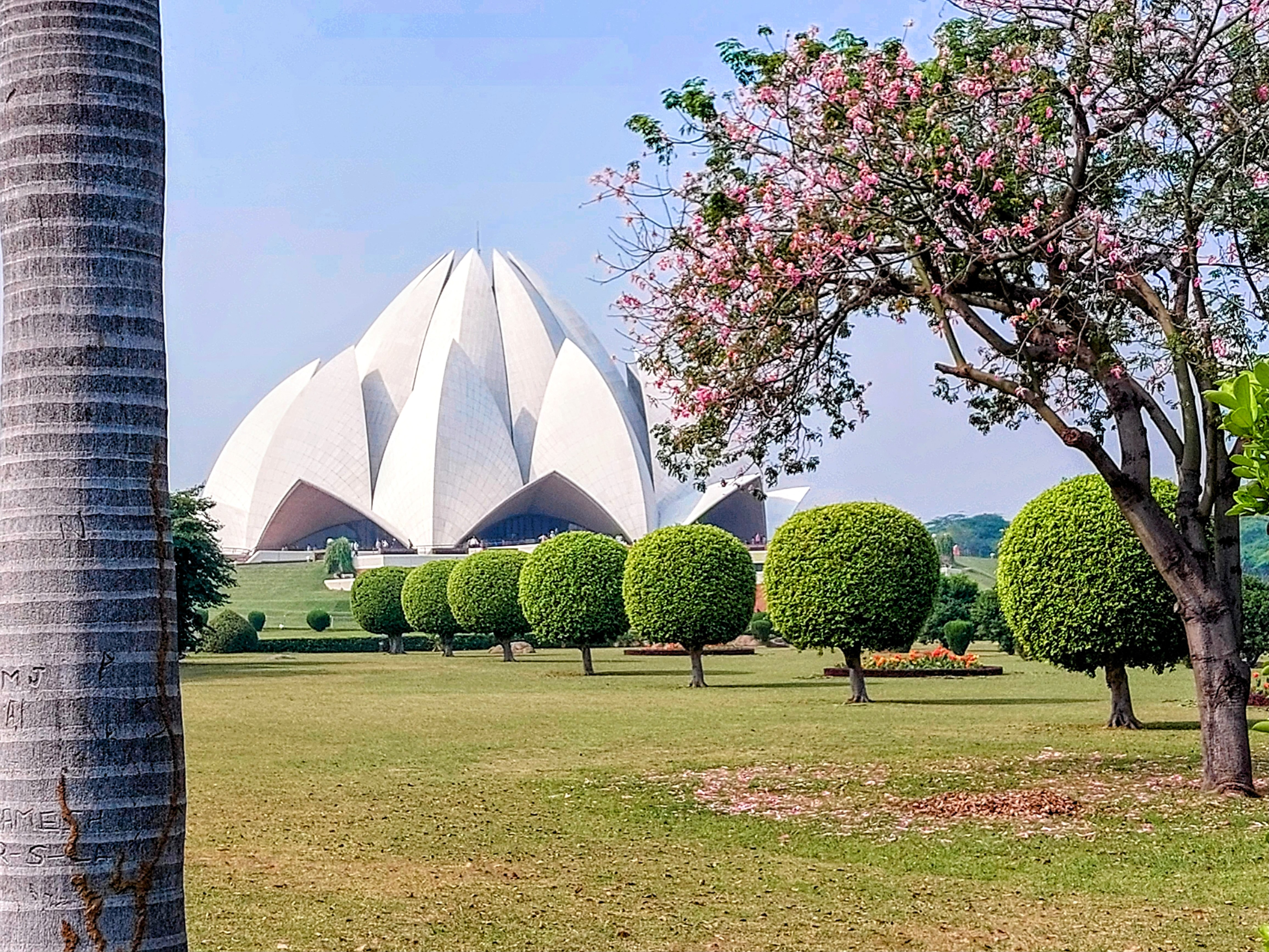 a white building with pointed roof and trees in front of it