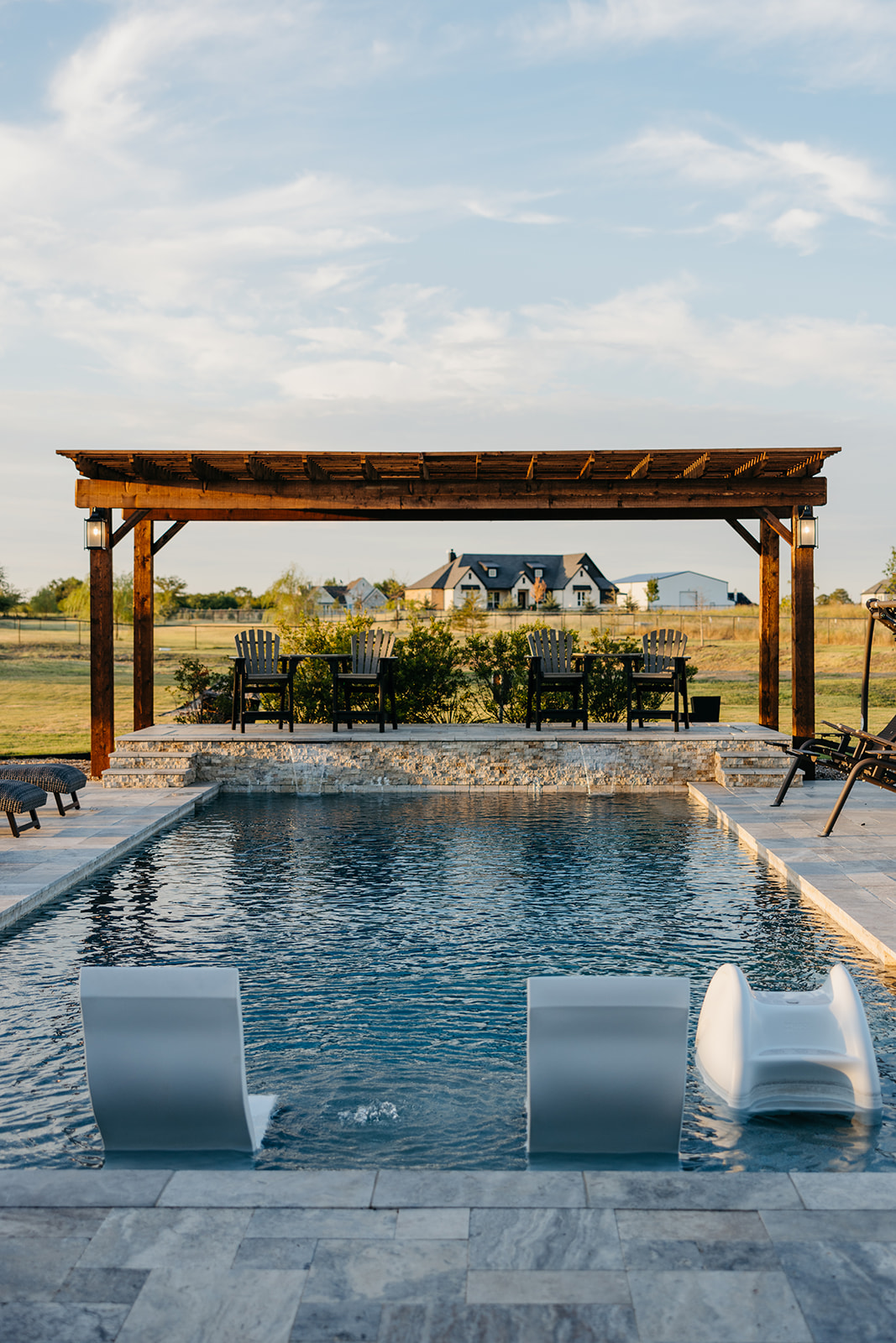 a pool with chairs and a pergola