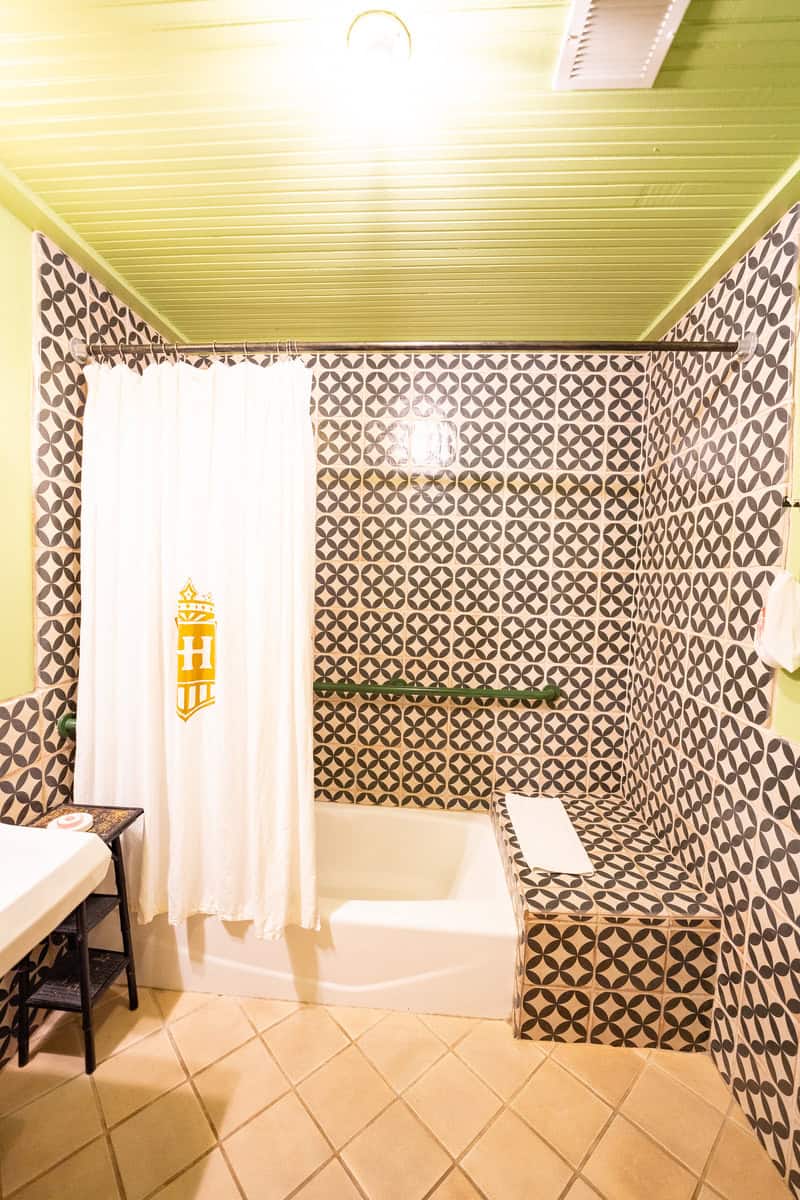 a bathroom with a white shower curtain and black and white tile