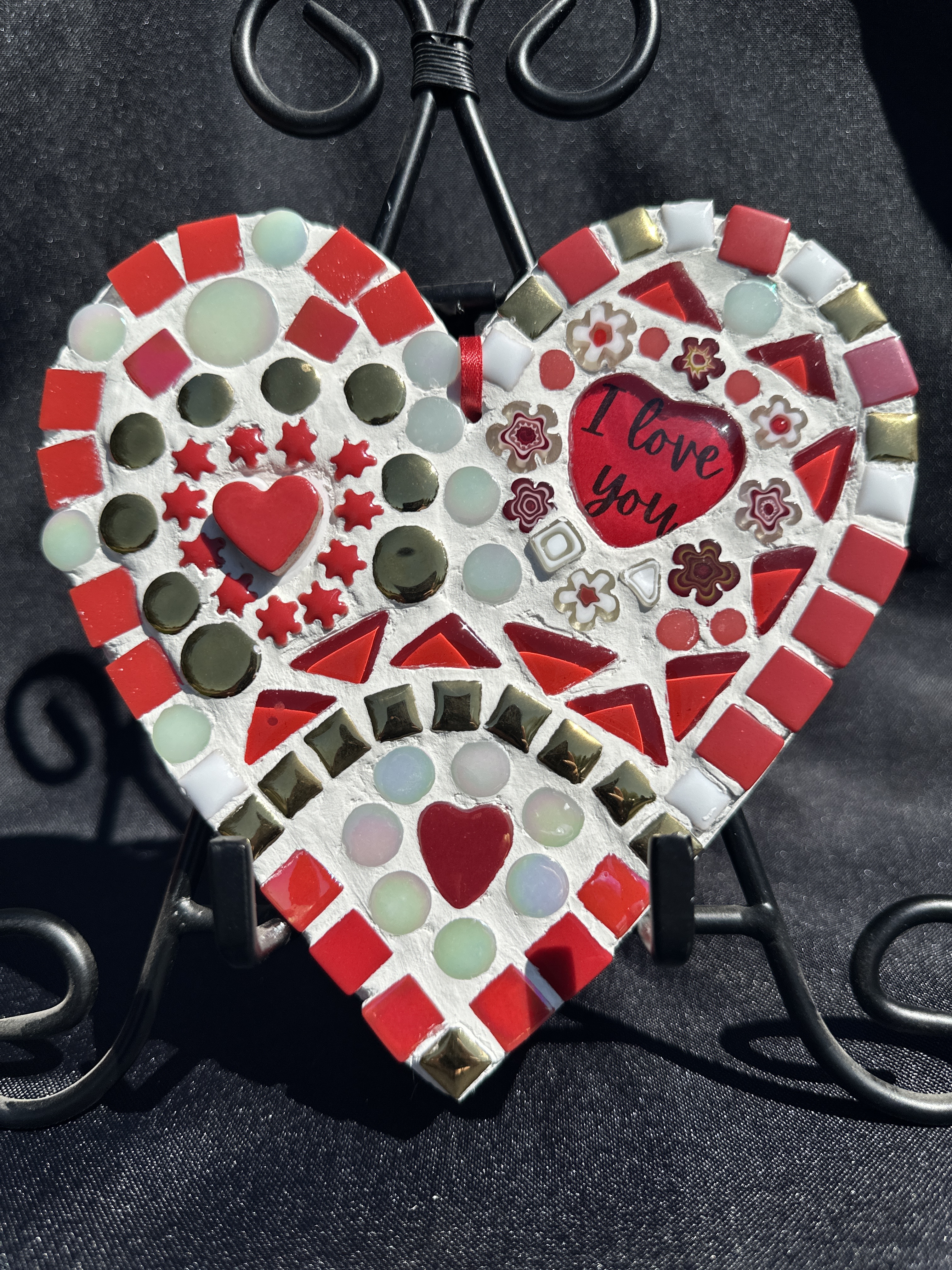 a heart shaped mosaic on a stand