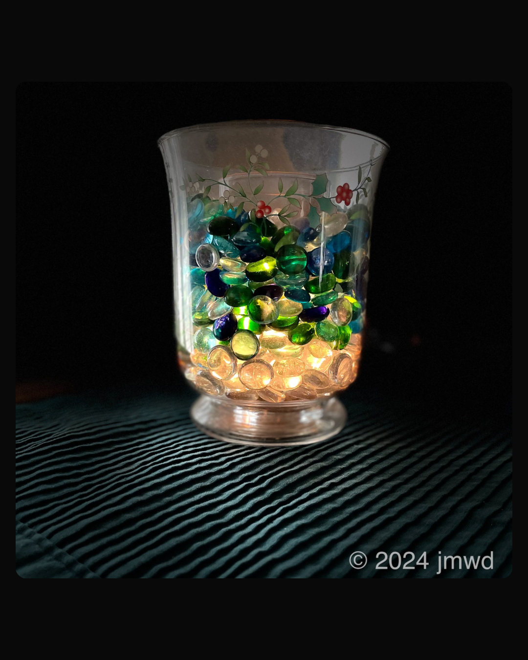 a glass with colorful pebbles inside