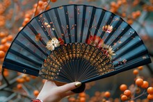 a hand holding a black and blue fan