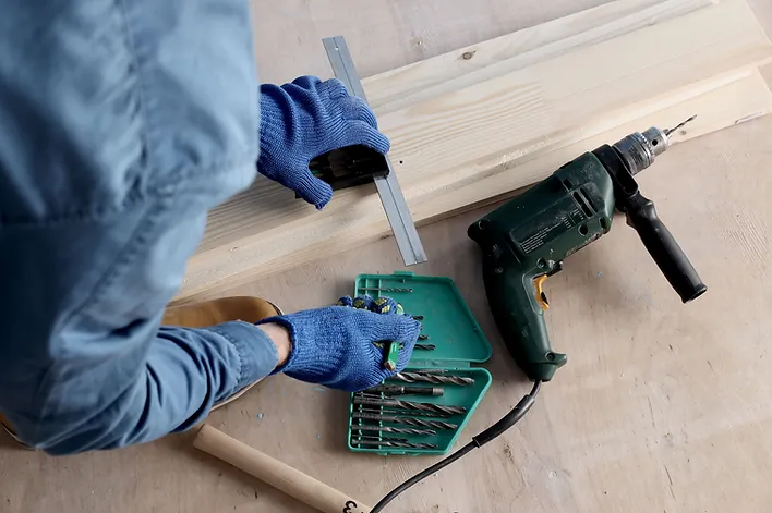 a person using a drill to drill wood