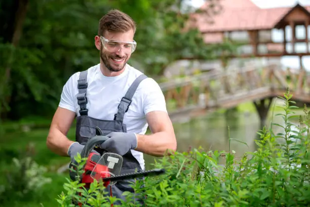 a man wearing safety goggles and holding a chainsaw