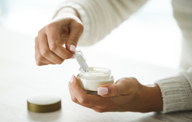 a person opening a jar of cream