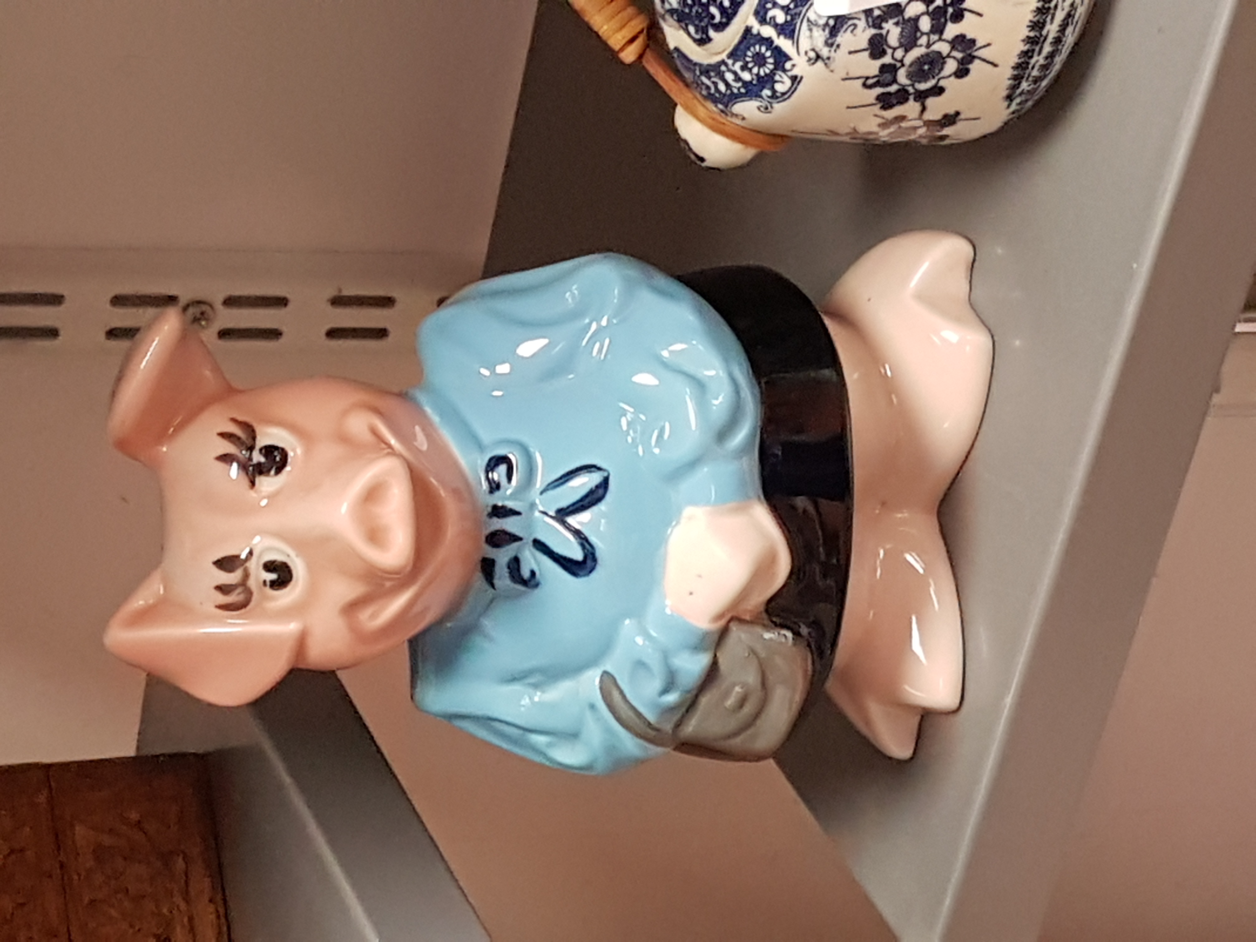 a ceramic pig figurine on a shelf