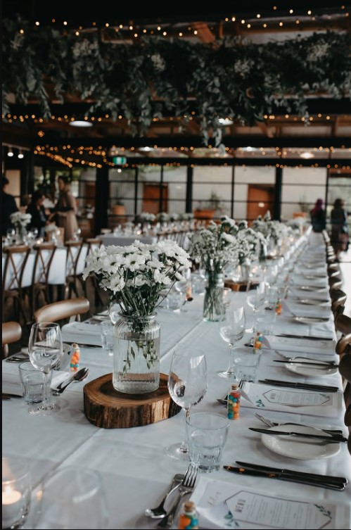 a long table with white flowers and glasses