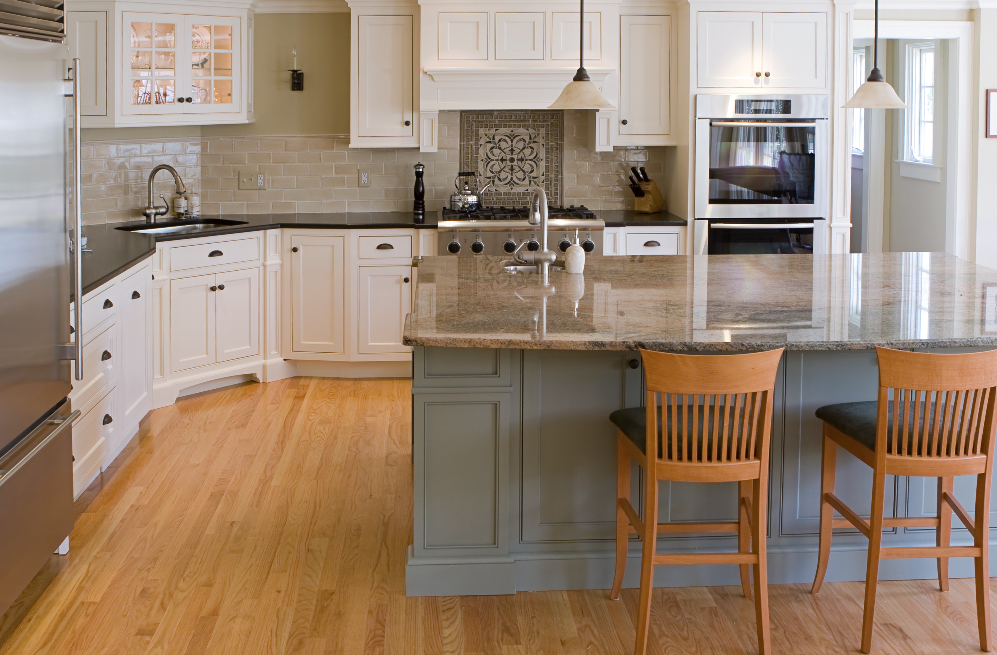 a kitchen with a marble island and white cabinets