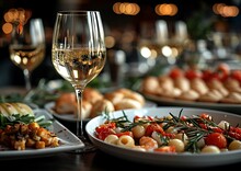 a table with plates of food and wine glasses