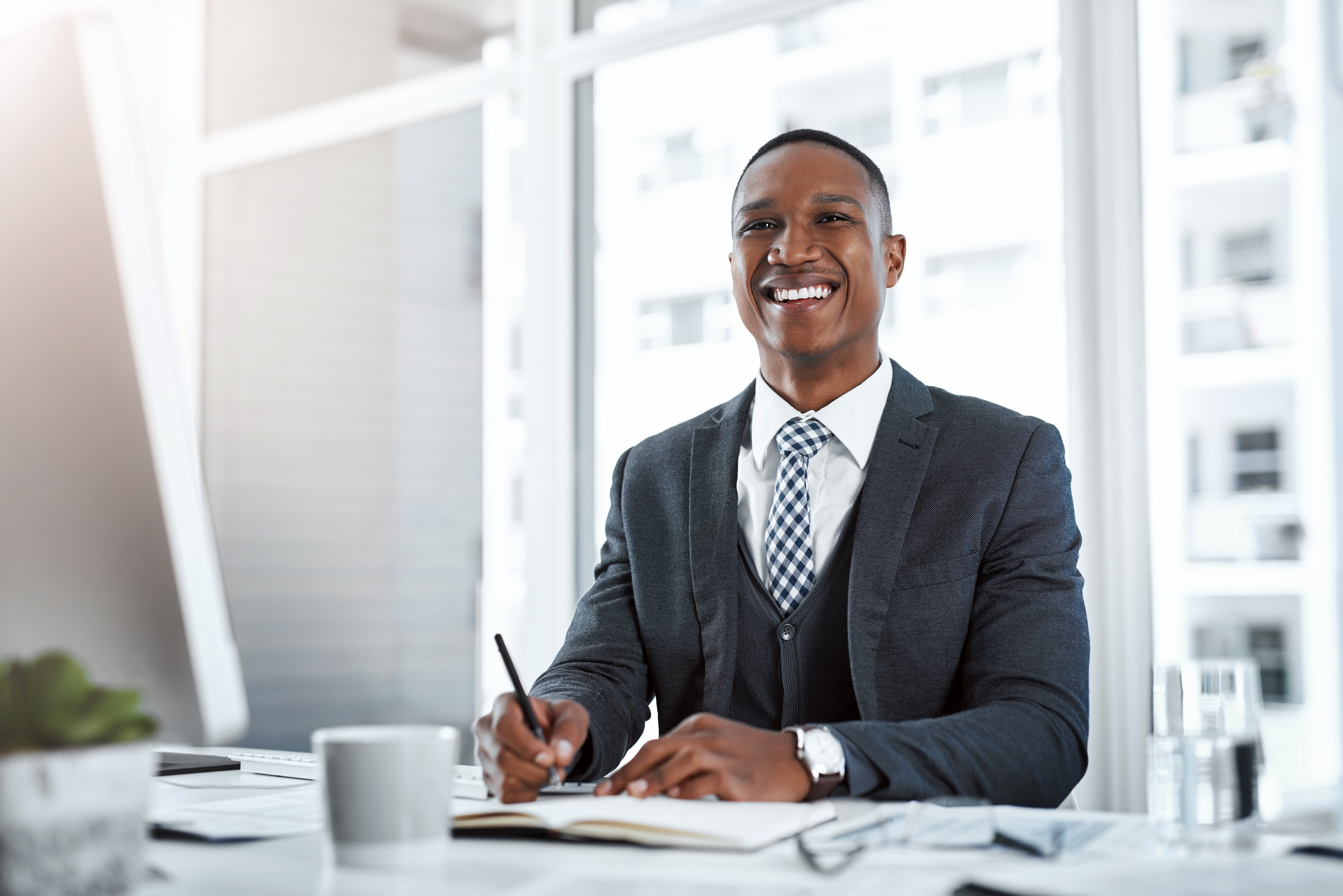 a man smiling at a computer