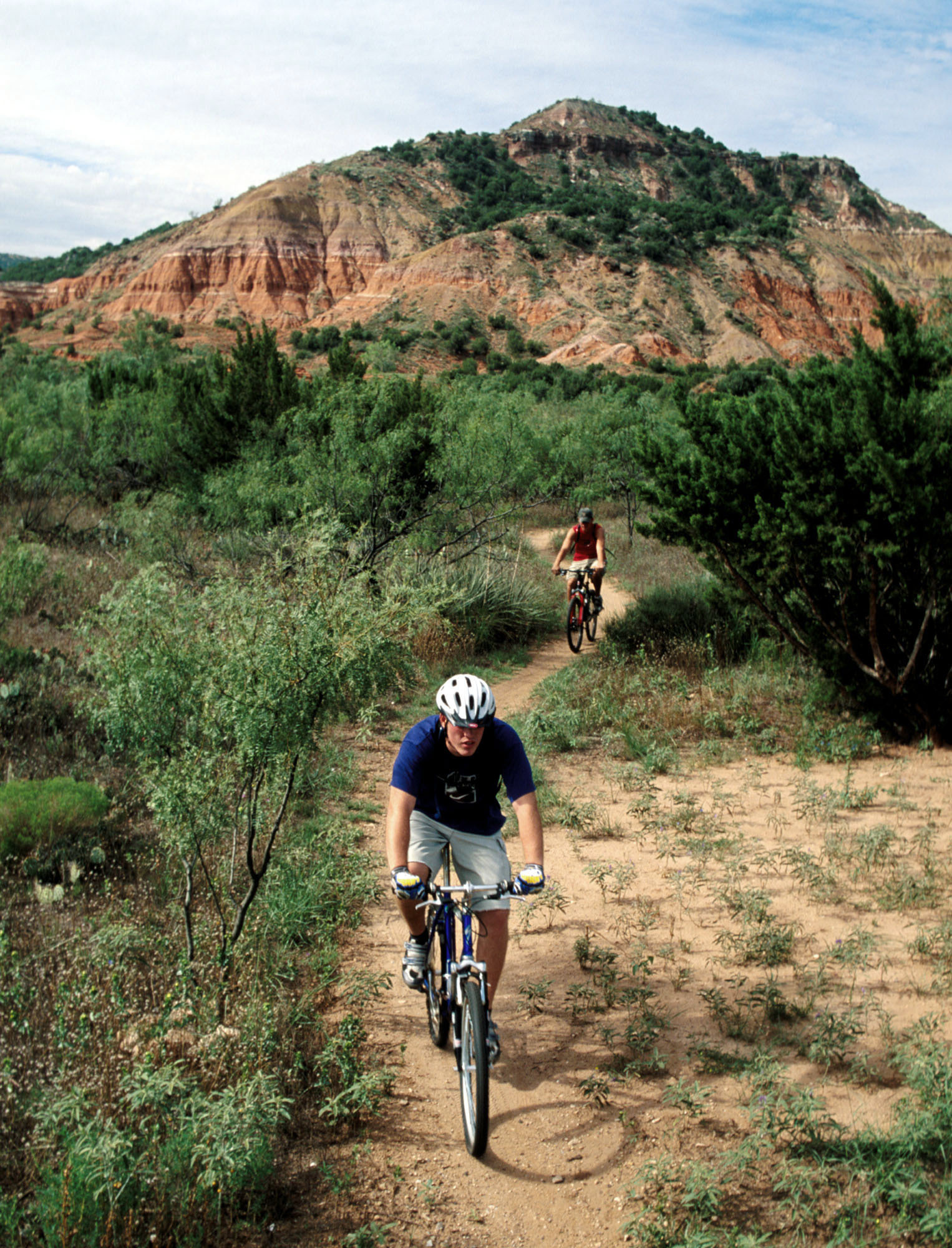 a group of people riding bikes on a dirt trail