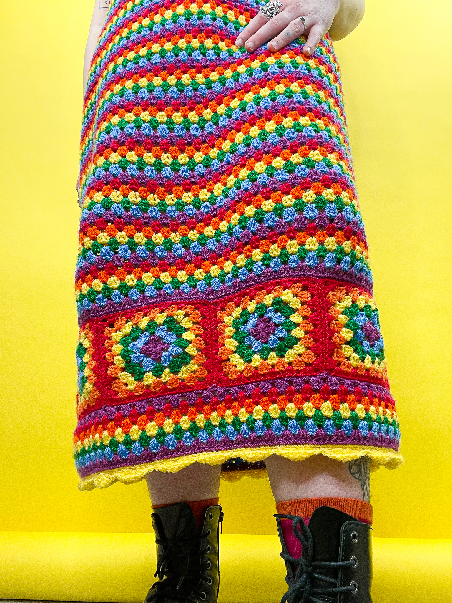 a person wearing a colorful crochet blanket