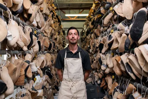 a man standing in a room with many shoes