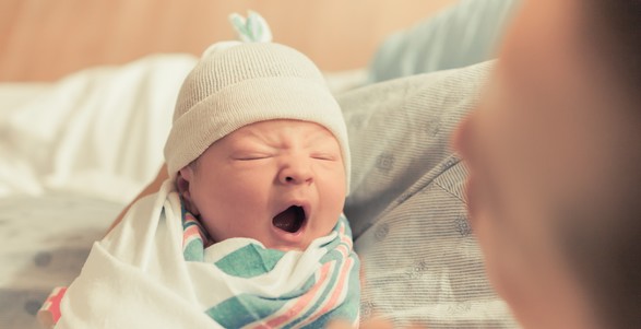 a baby yawning in a hospital bed