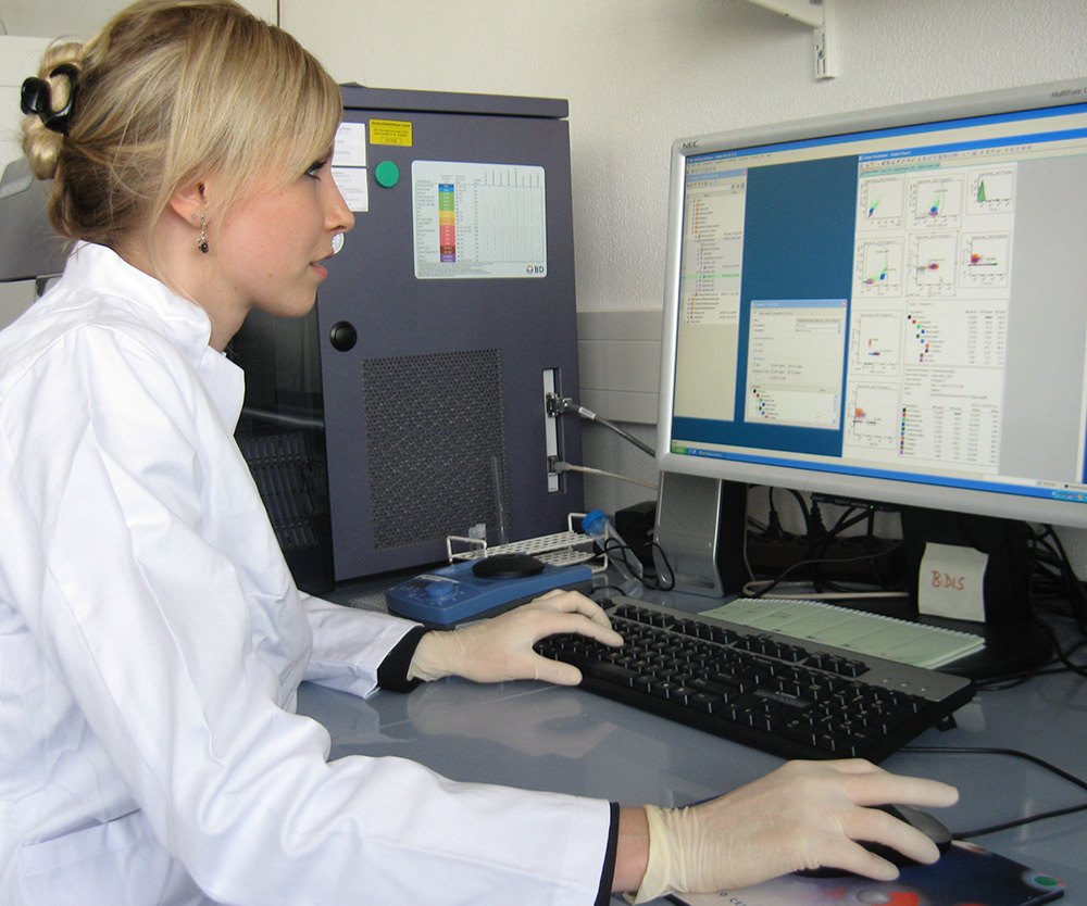 a woman in a lab coat typing on a keyboard