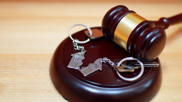 a gavel and key chain on a wooden surface
