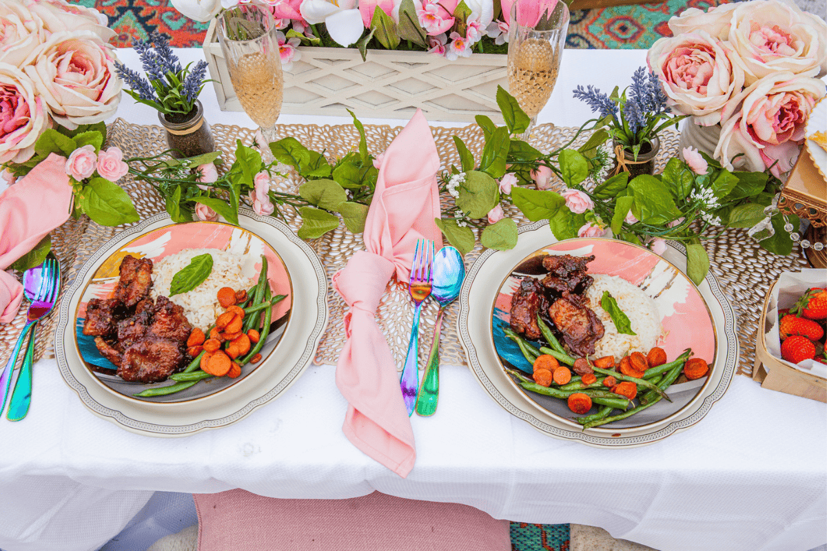 a table with plates of food and flowers