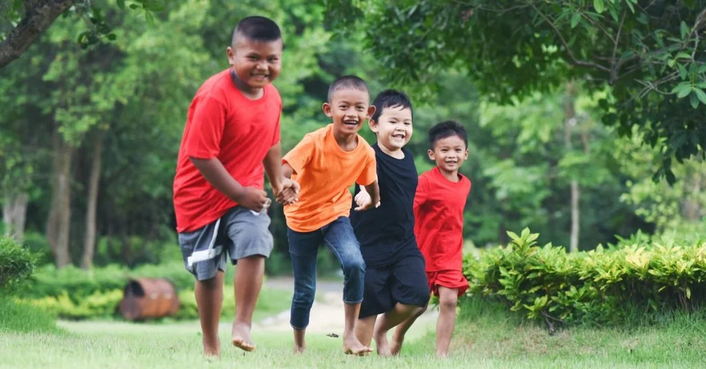 a group of boys running in grass