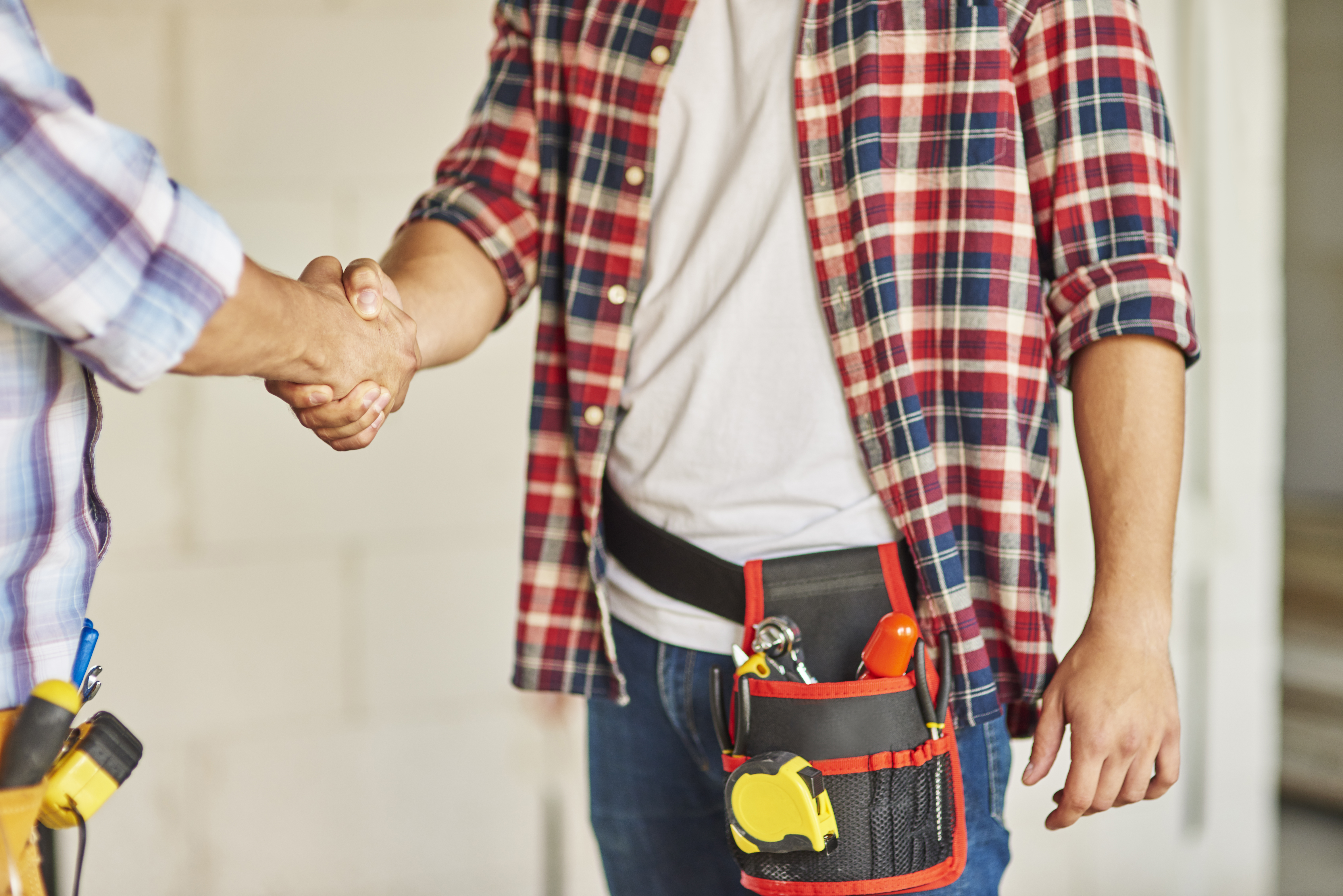 a man shaking hands with a tool belt