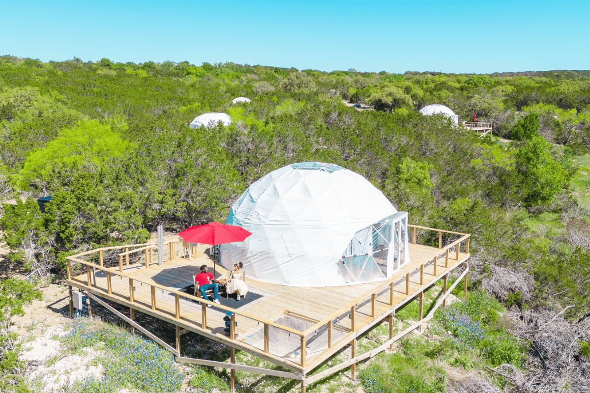 a person sitting on a deck with a white dome on top of it