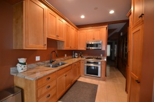 a kitchen with wooden cabinets and a marble countertop