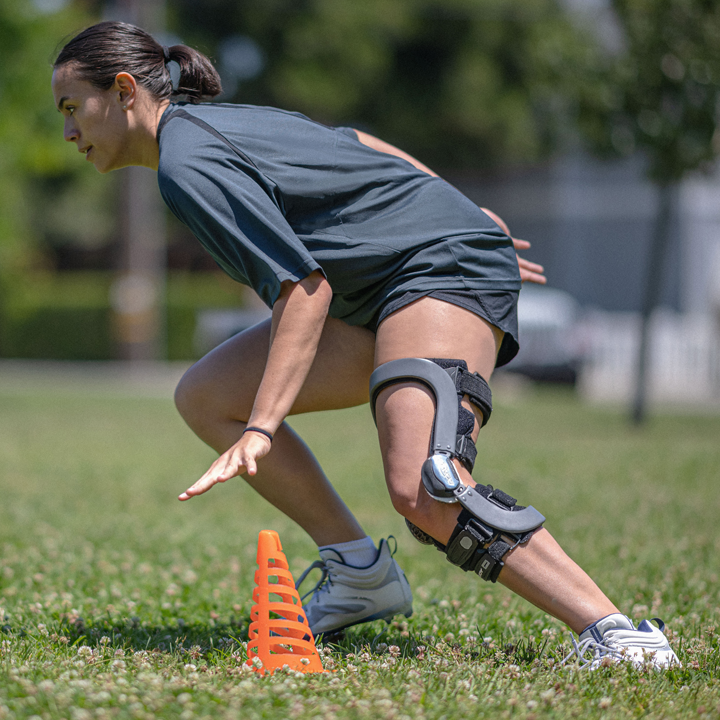 a woman with knee braces and a small cone