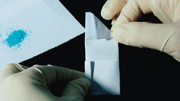 hands in gloves folding a paper