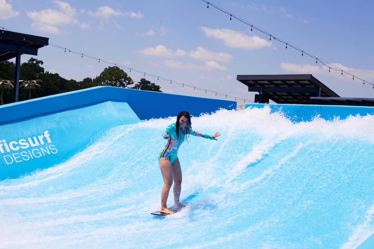 a woman on a surfboard in a water park