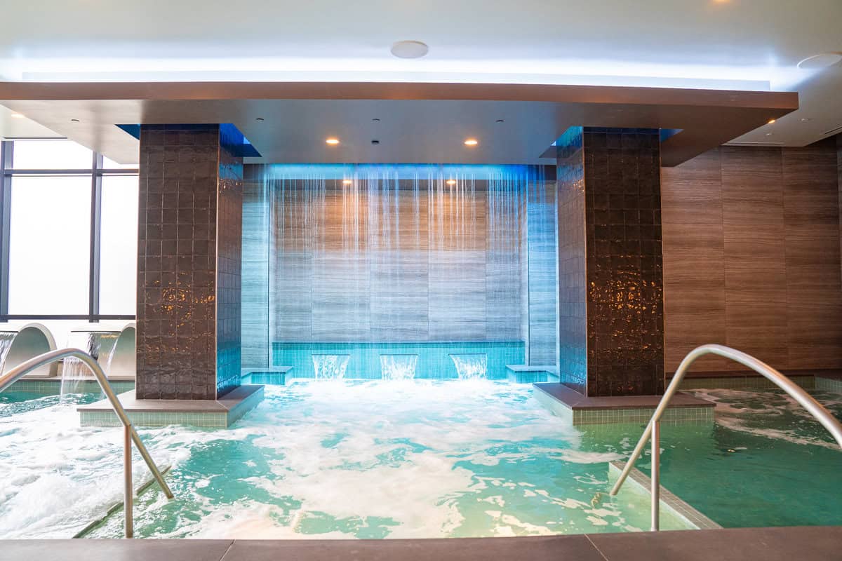 a indoor pool with water falling from the ceiling