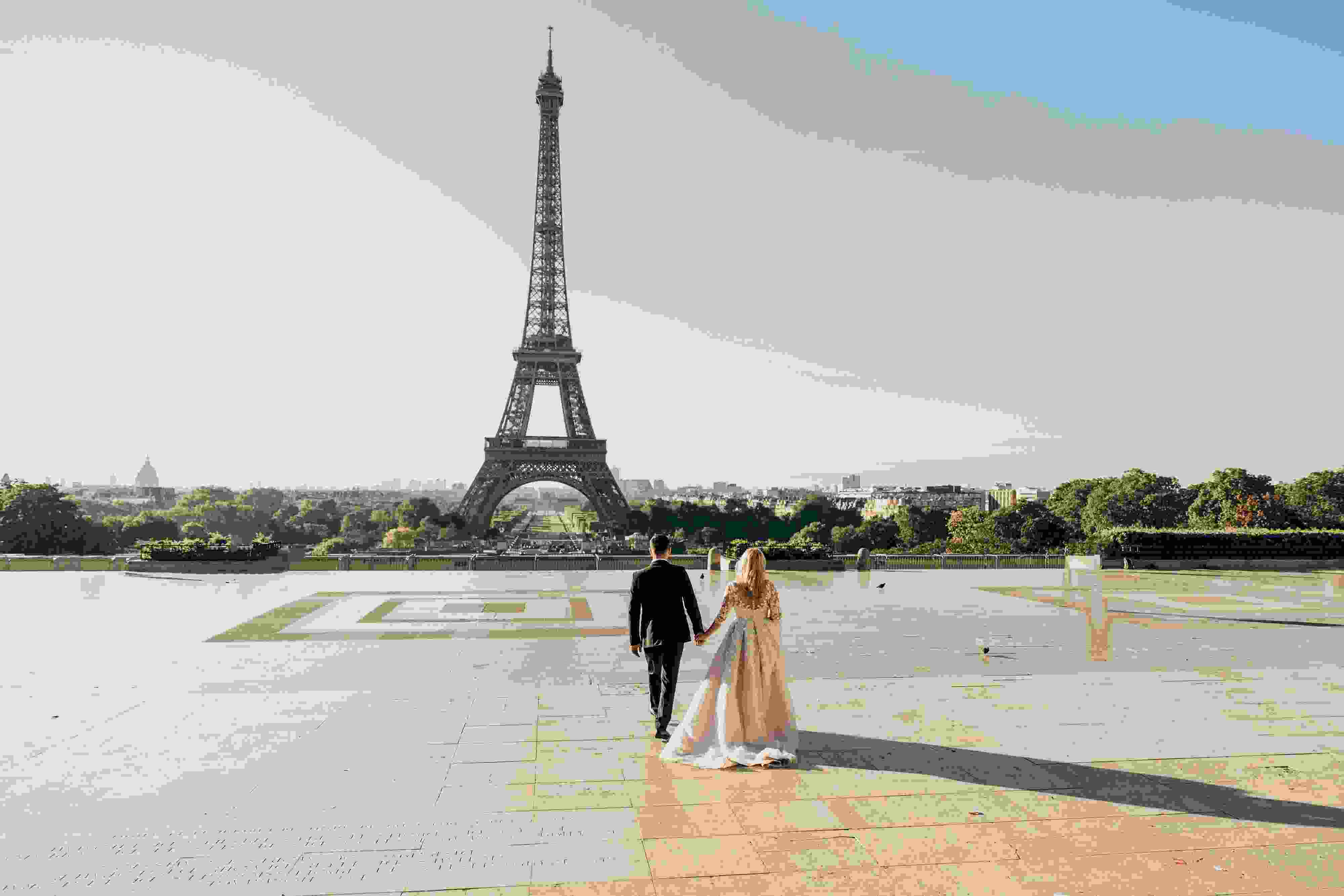 a man and woman walking in front of Eiffel Tower
