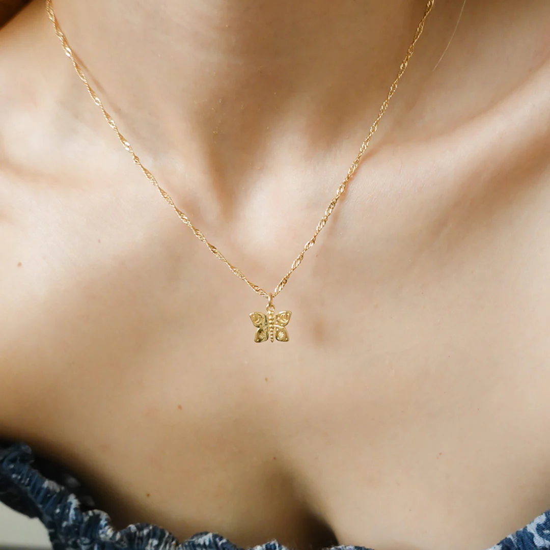 a woman wearing a butterfly necklace