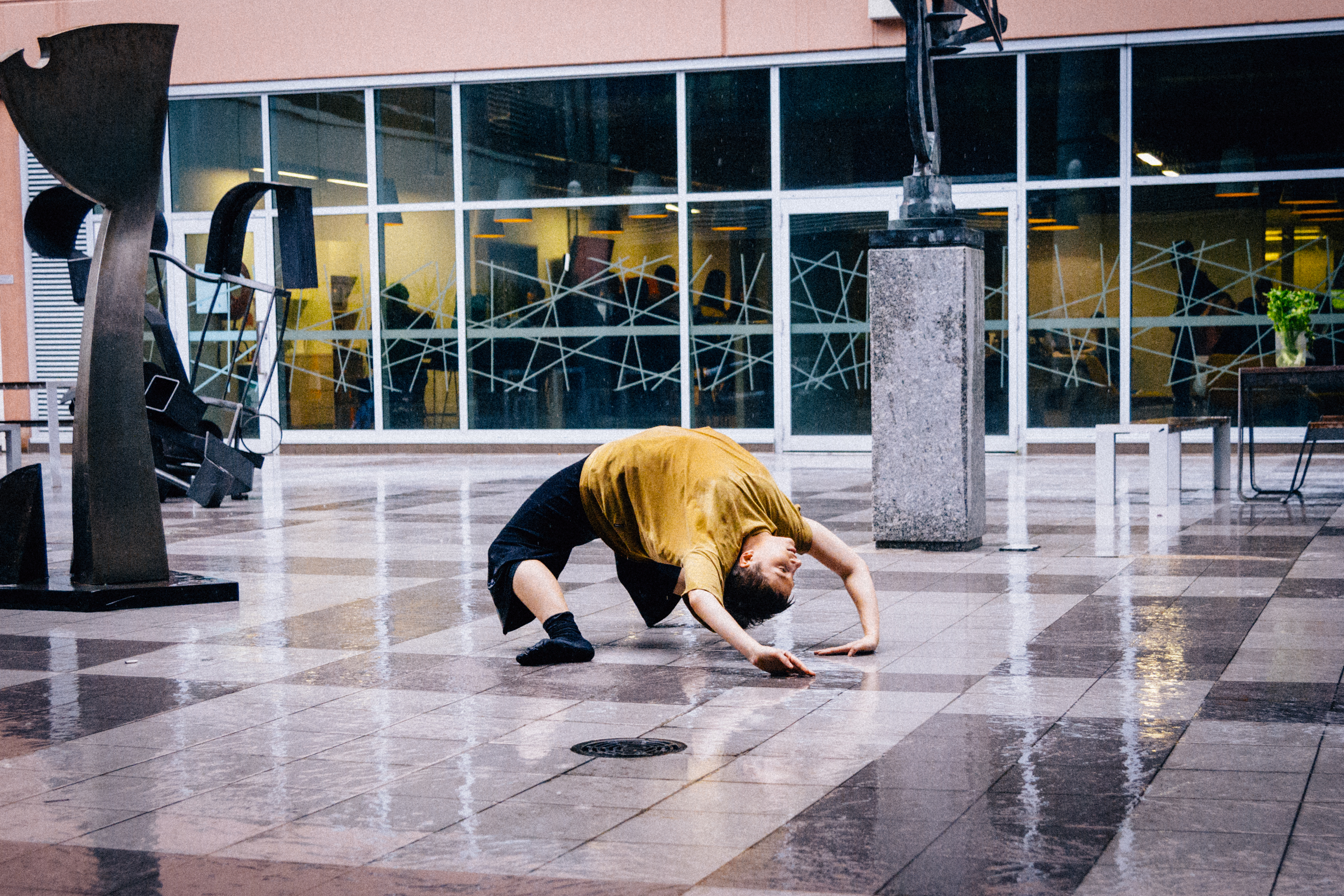 a man doing a hand-bending pose on a wet floor