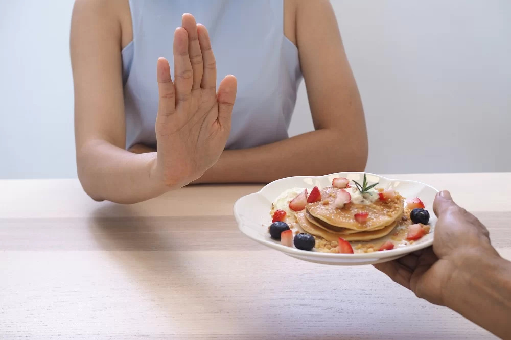 a person holding a plate of pancakes with berries on it