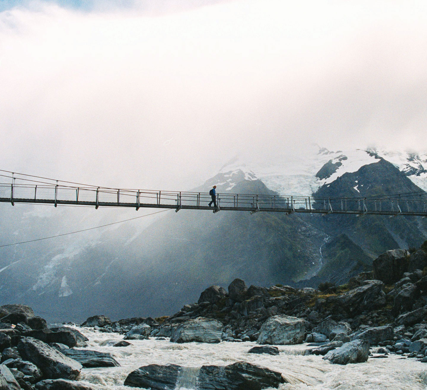 a person walking on a bridge over a river