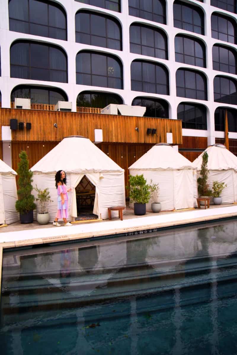 a woman standing in front of a pool of tents