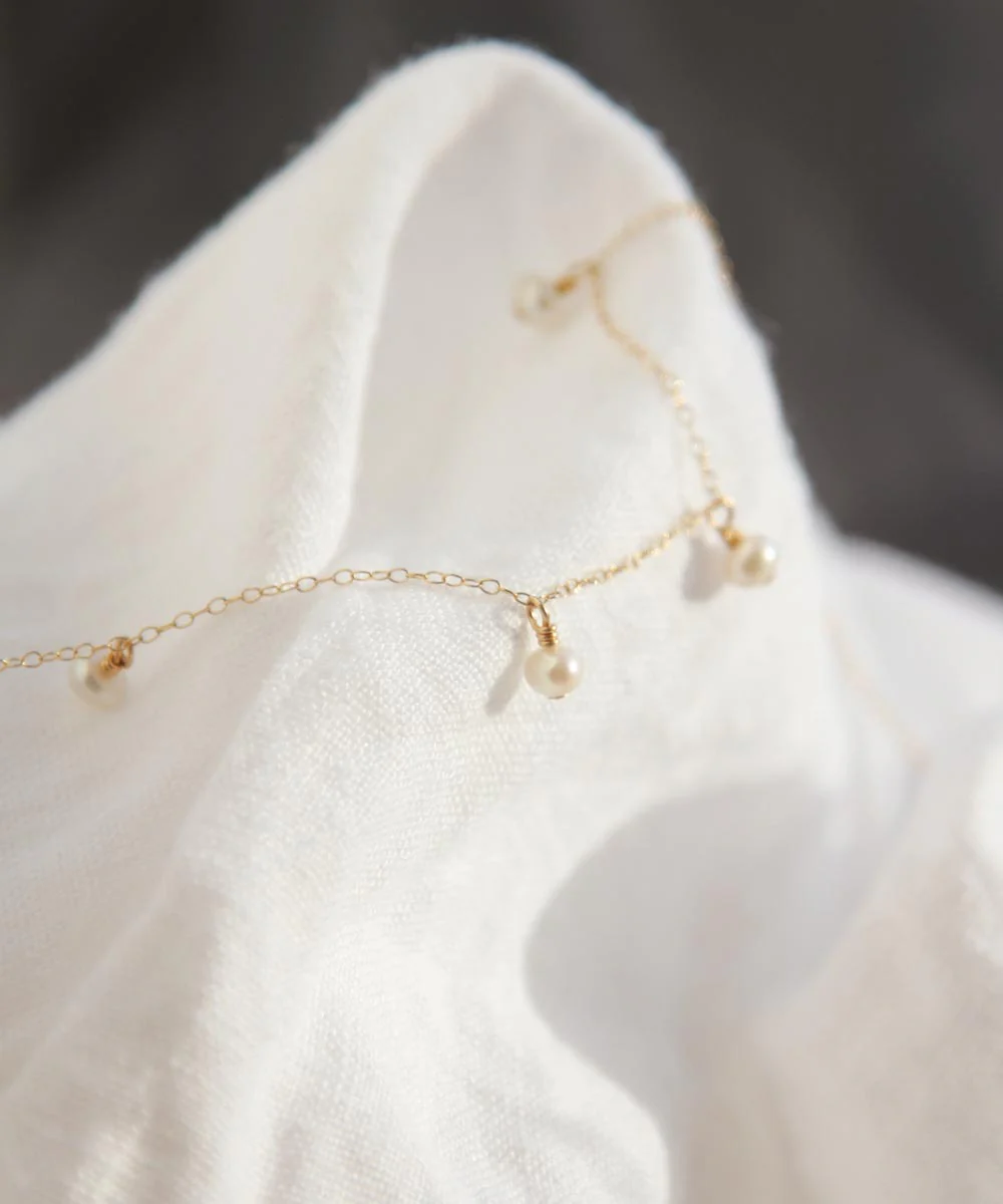 a gold chain with pearls on it